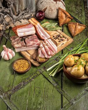 Ham and vegetables on an old wooden background