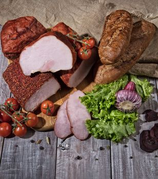 Ham and vegetables on an old wooden background