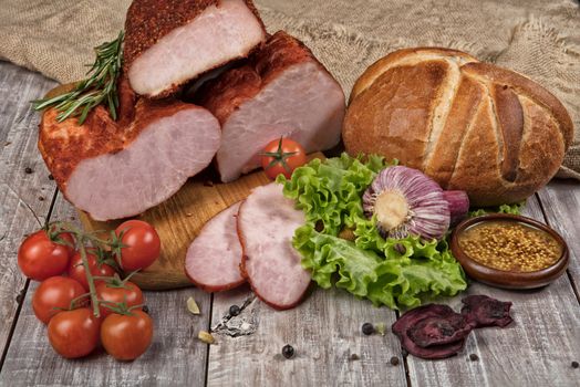 Ham and vegetables on an old wooden background