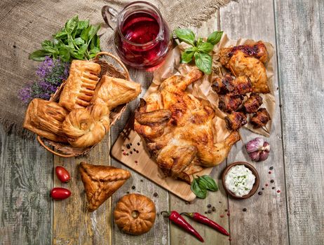 Roasted chicken, juice and bakery on an old wooen desk