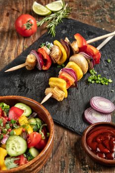 Shaslik and vegetables on a wooden table