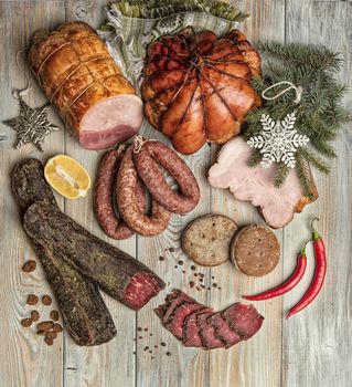 Ham and vegetables on an old wooden background