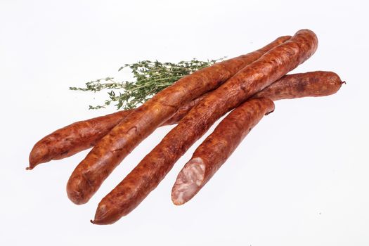 Sausage with greenery on an isolated studio background