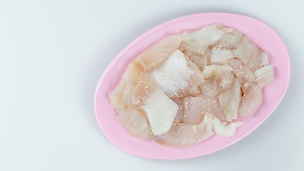 top view raw  fish with white sesame seed on plate on white background