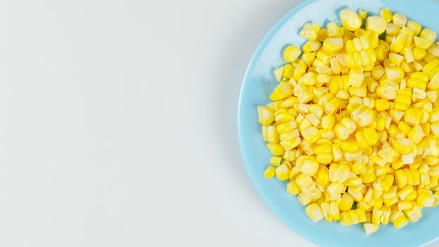 top view raw sweet corn on blue plate with copy space