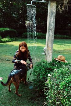 Asian woman washing her pet dog