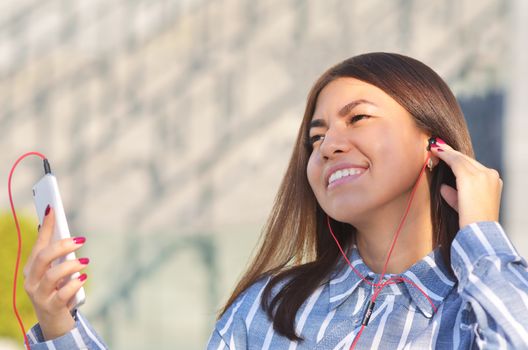 Beautiful girl on a Sunny spring day listening to music and enjoying life