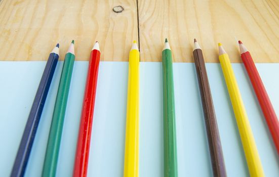 Colored pencils, blue and wooden background, back to school, copy space, top view, SELECTIVE focus.