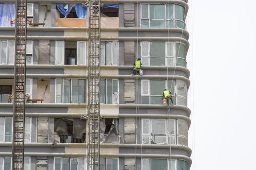 Worker scaffolding on the side of the building