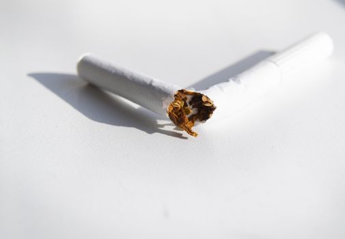 Broken cigarette on white background, Smoking cessation concept, minimalism style, selective focus.