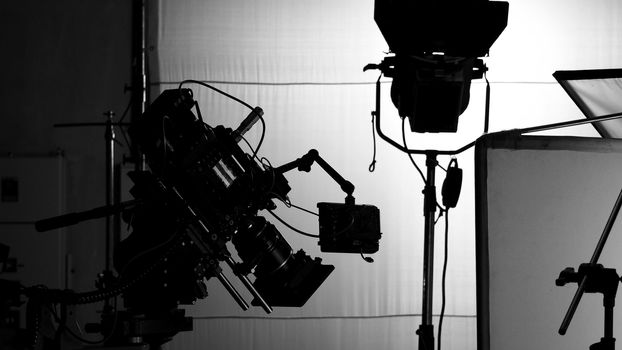 Video camera in film or movie production on tripod and professional gear which shooting in location or studio with crew team and beautiful prop or set and ready to online live broadcast or tv on air later 