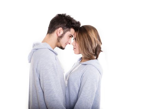Young couple standing face-to-face in white studio