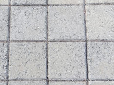 Close-up of cement block paving with square pattern, not new.