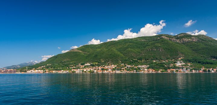 Small tourist villages on the Bay of Kotor in Montenegro, in a sunny summer day. The beginning of the cruise from Tivat city.