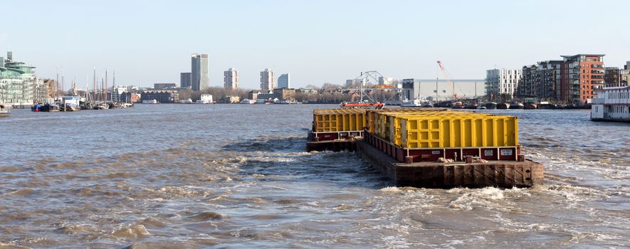 London, United Kingdom - Februari 21, 2019: Tugboat and Container Barge at Thames River. Shipping Municipal Garbage To Waste Management Facility, London, England