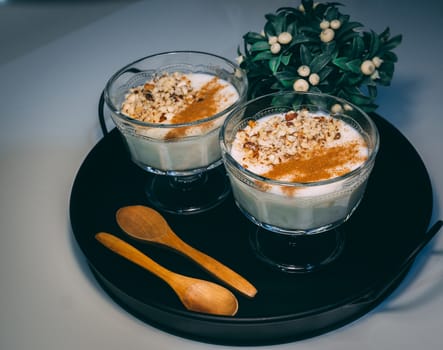 Homemade dessert decorated with flower on black tray.