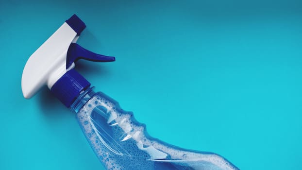 Spray with detergent on blue background. Housework, housekeeping and household concept