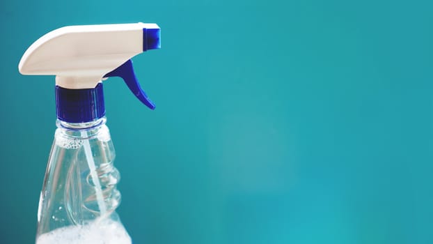 Spray with detergent on blue background. Housework, housekeeping and household concept