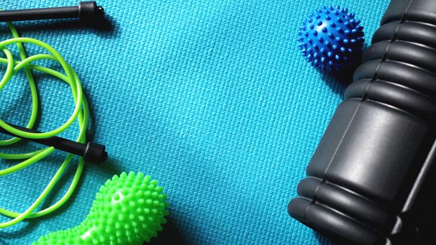 Massage ball and roller for self massage, reflexology and myofascial release, blue background. Equipment for sports, yoga, fitness