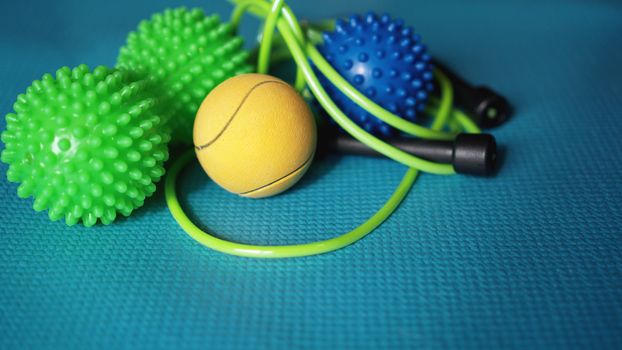 Massage ball and roller for self massage, reflexology and myofascial release, blue background. Equipment for sports, yoga, fitness