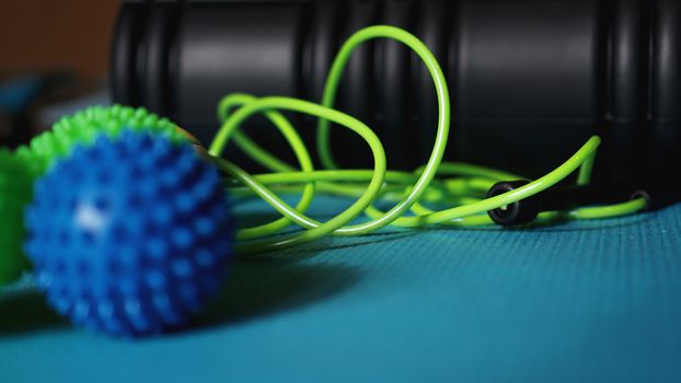 Massage ball and roller for self massage, reflexology and myofascial release, blue background. Equipment for sports, yoga, fitness