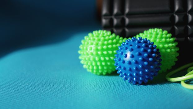 Massage ball and roller for self massage, reflexology and myofascial release, blue background. Equipment for sports, yoga, fitness