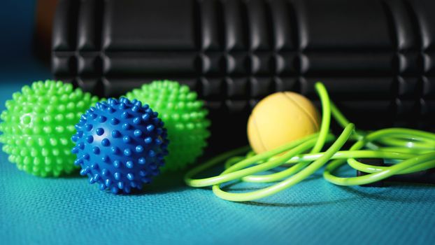 Massage ball and roller for self massage, reflexology and myofascial release, blue background. Equipment for sports, yoga, fitness