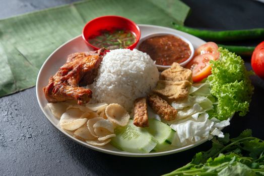 Nasi lemak kukus with fried drumstick, popular traditional Malaysian local food.
