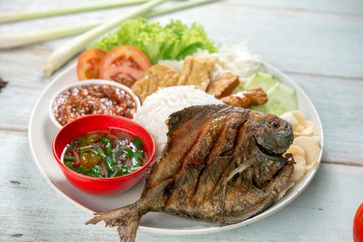 Fried pomfret fish and rice, popular traditional Malay or Indonesian local food.
