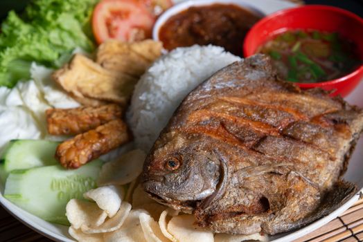 Fried pomfret fish and rice, popular traditional Malay or Indonesian local food.