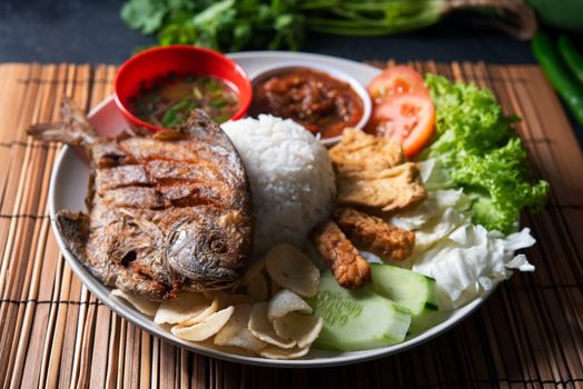 Fried pomfret fish and rice, popular traditional Malay or Indonesian local food.