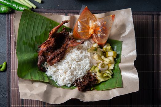 Nasi lemak kukus with quail, popular traditional Malay local food. Flat lay top down overhead view.