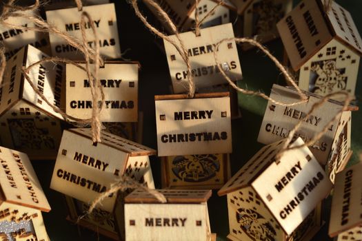 Wooden Christmas ornaments in shape of house with Merry Christmas wording on the roof