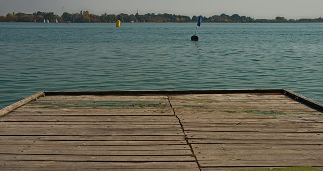 Rustic wooden pier and lake with other shore