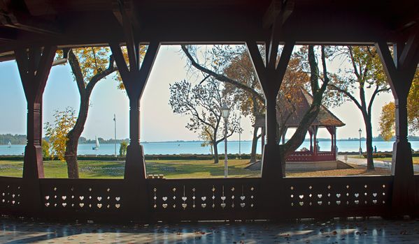 Look from open wooden bungalow on park and lake