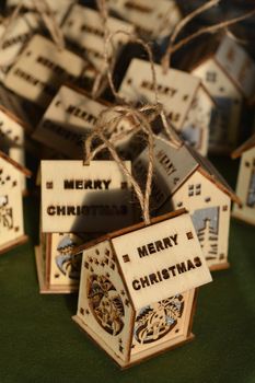 Wooden Christmas ornaments in shape of house with Merry Christmas wording on the roof