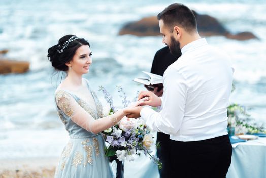 wedding couple on the ocean with a priest