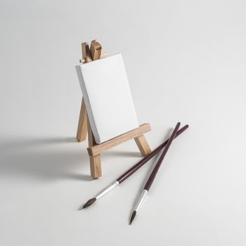 An easel with canvas and brushes