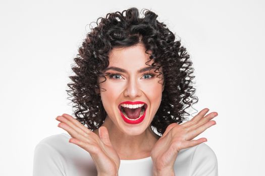 Surprised young woman shouting over white background. Looking at camera