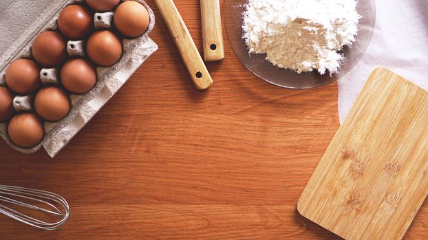 Ingredients and utensils for baking on a pastel wooden background, top view. Concept of kitchen, cooking and Easter