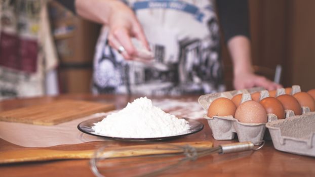 Close up scene of female hands making dough. Soft focus, kitchen, cooking ingredients