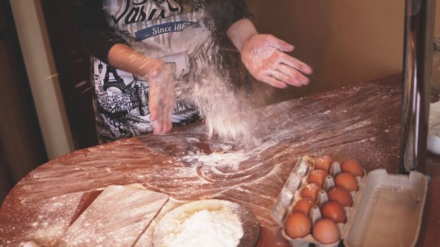 Close up scene of female hands making dough. Soft focus, kitchen, cooking ingredients