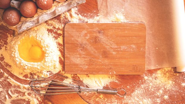 Ingredients and utensils for baking on a pastel wooden background, top view. Concept of kitchen, cooking and Easter