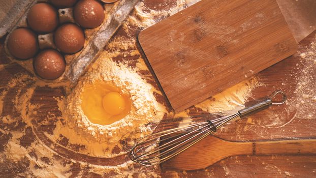 Ingredients and utensils for baking on a pastel wooden background, top view. Concept of kitchen, cooking and Easter