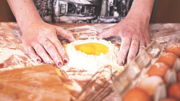 Professional female baker cooking dough with eggs and flour for Easter baking