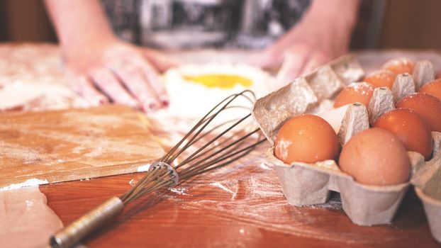 Professional female baker cooking dough with eggs and flour for Easter baking