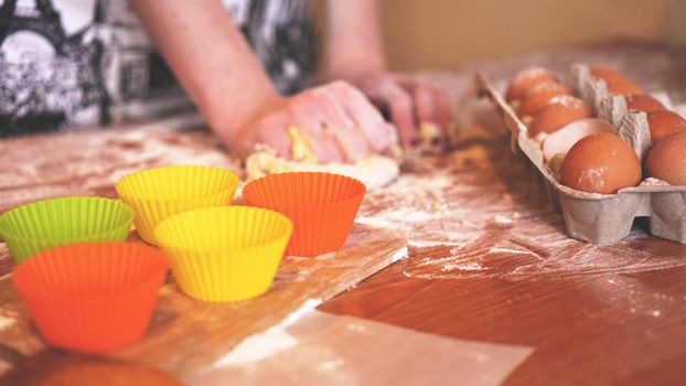 Cooking and home concept - close up of female hands kneading dough at home. Soft focus