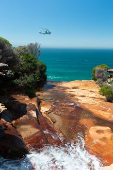 The army helicopter came in real close to look at the waterfalls as they cascade over rocks and into the ocean. A sea fog out on the horizon