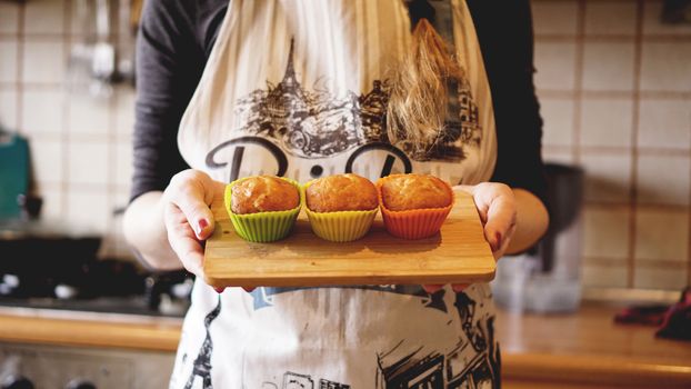 Homemade caramel muffins in a baking dish in the hands of the confectioner. Dessert for gourmet. Selective focus