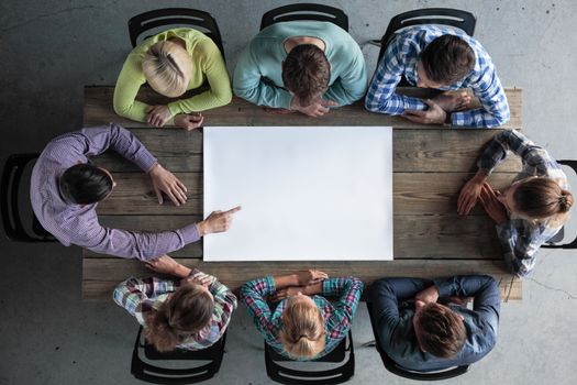 Hipster business teamwork brainstorming planning meeting concept, people team sitting around the table with white blank paper with copy space for text